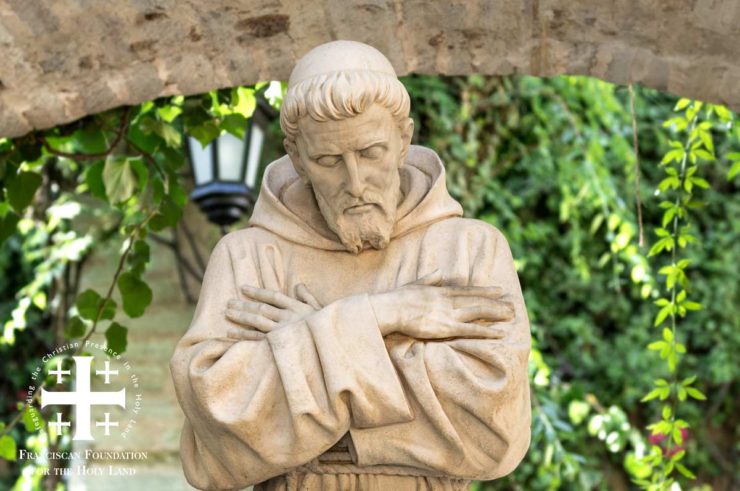 statue of St. Francis Assisi with arms crossed