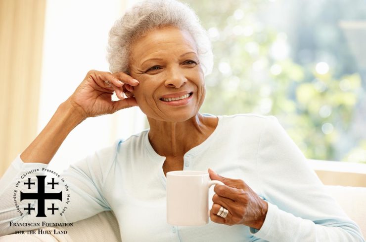 Retirement aged woman smiling with coffee